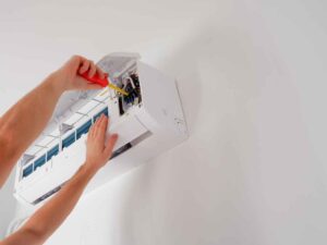 HVAC technician installing a new air conditioning unit and performing maintenance