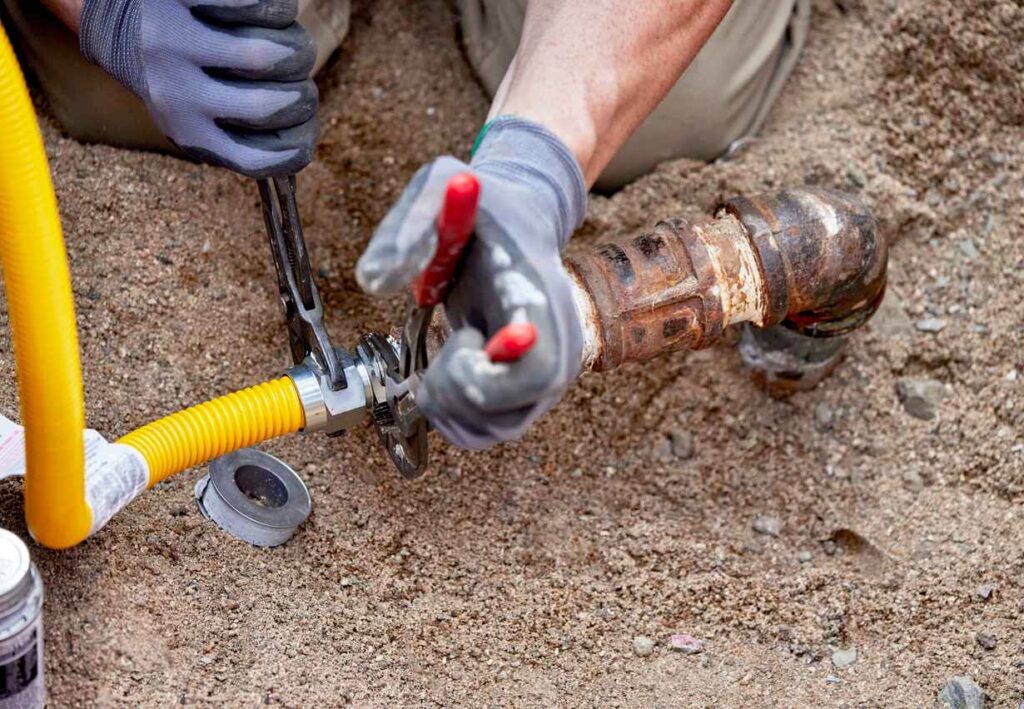 A Plumber hooking up a temporary gas line to a propane tank