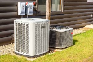 Heating and air conditioning system external units on grass in a house backyard.