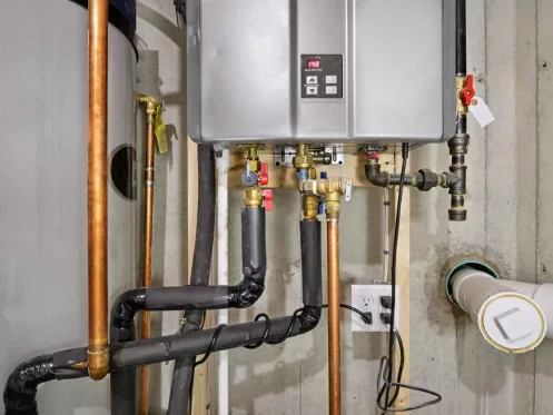 Tankless hot water heater connected to a recirculation system and storage tank
